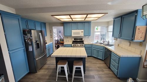The same kitchen after the cabinets were sprayed in a custom blue