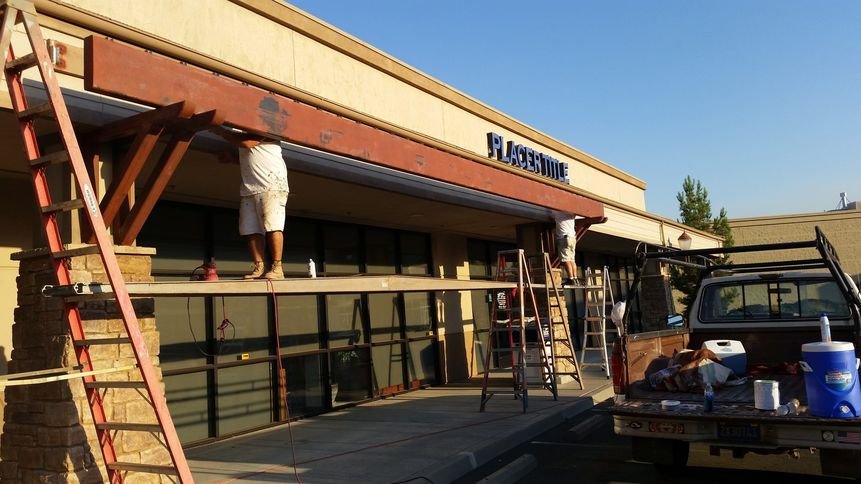 A Michael Hines Painting crew on scaffolding repainting the exterior of the Placer Title building