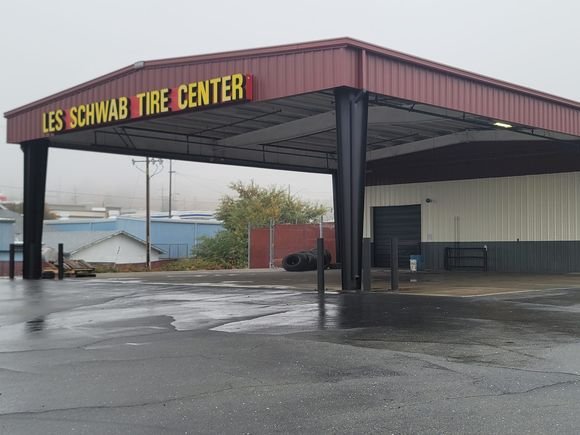 The Les Schwab Tire Center canopy with fresh red paint and the yellow sign overhead