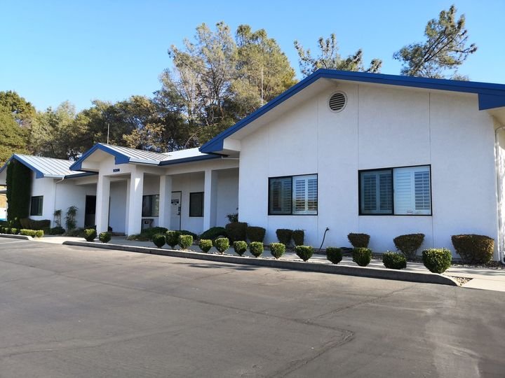 A freshly painted single-story medical office with clean white walls and blue trim