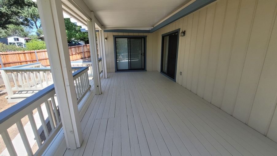 The same deck after refinishing, the old finish stripped and the boards recoated to an even, clean solid color
