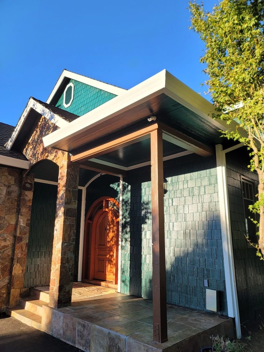 The arched entry of a repainted foothill home at golden hour, stone accent and crisp trim around the door