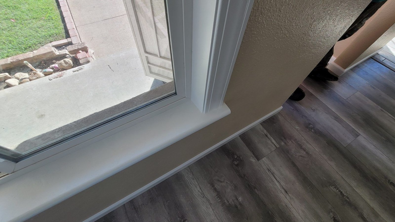 Close-up of an interior wall meeting the trim, the line cut clean by hand