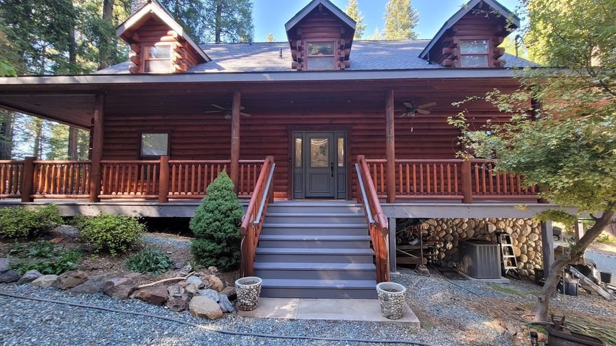 A well-kept amber log home with fresh stain, front steps and tidy landscaping